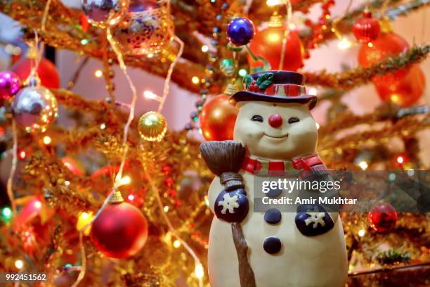 snowman (toy) against christmas decorations and lights - amir mukhtar stock pictures, royalty-free photos & images