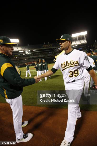 Manager Bob Melvin and Blake Treinen of the Oakland Athletics celebrate on the field following the game against the Kansas City Royals at the Oakland...