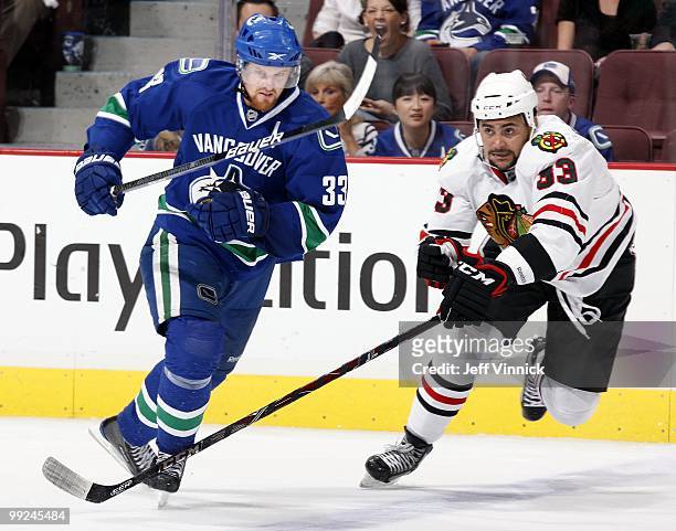 Henrik Sedin of the Vancouver Canucks and Dustin Byfuglien of the Chicago Blackhawks skate up ice in Game 6 of the Western Conference Semifinals...