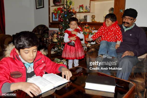 christian family reading bible and praying on christmas 2017 - amir mukhtar stock pictures, royalty-free photos & images