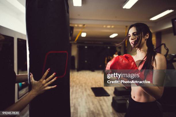 jovem mulher atlética socando um saco em um treinamento de boxe - sparring training - fotografias e filmes do acervo