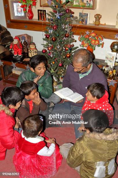 pakistani christian family reading bible and praying on christmas 2017 - amir mukhtar stock pictures, royalty-free photos & images