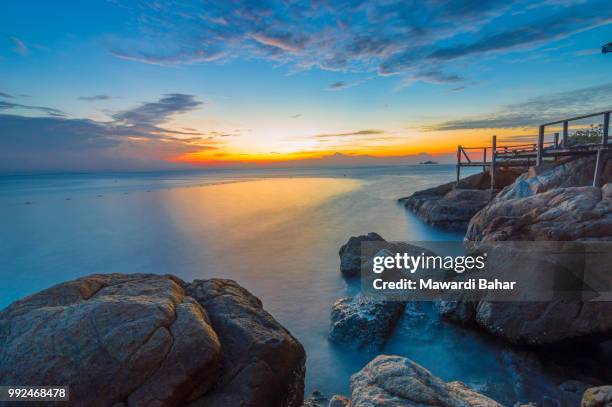 beach rock with sunset and wave with slow shuttle - wave rock stock pictures, royalty-free photos & images