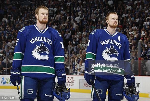 Daniel Sedin and Henrik Sedin of the Vancouver Canucks listen to the national anthem in Game 6 of the Western Conference Semifinals against the...