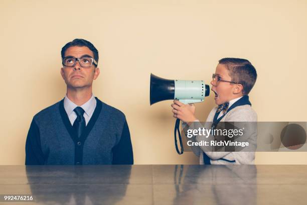 young nerd boy yelling at dad through megaphone - ignorance stock pictures, royalty-free photos & images