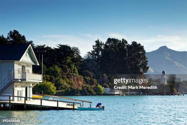 man tending boat in akaroa - new zealand beach house stock pictures, royalty-free photos & images