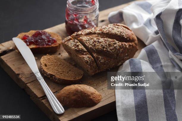 dark multigrain bread whole grain and jam fresh baked on rustic - marmorkuchen stock-fotos und bilder