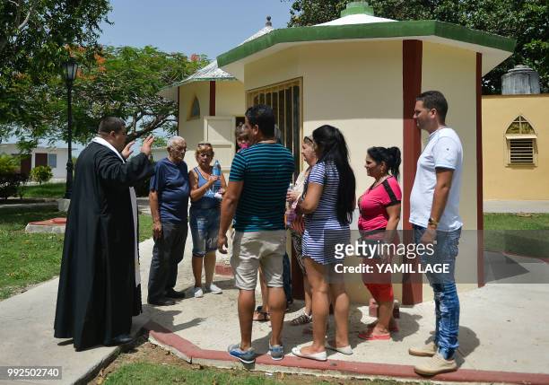 Priest Elixander Torres talks to believers at a new little chapel built with donations from Cubans living abroad, at Saint Lazarus National Sanctuary...