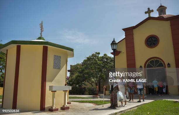 People walk towards a new little chapel built with donations from Cubans living abroad outside the Saint Lazarus Church at Saint Lazarus National...