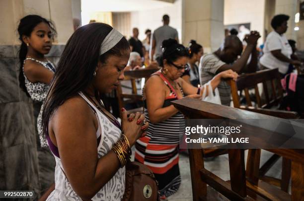 Cuban pilgrims pray at Saint Lazarus Church in El Rincon, Havana, on July 2, 2018 - Saint Lazarus draws together Cuban interconfesional faith in a...