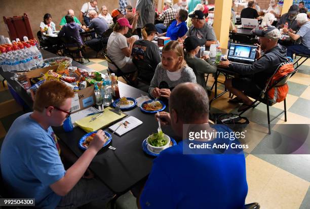 John Cude, lower left, his mother Sondra, center, and father Robert Cude, lower right, enjoy a hot meal inside the American Red Cross shelter at the...