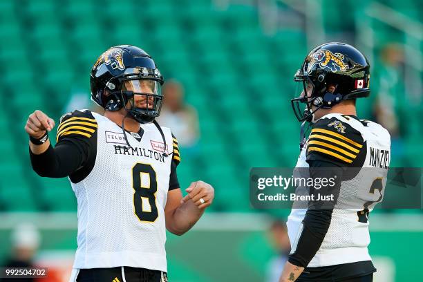 Jeremiah Masoli and Johnny Manziel of the Hamilton Tiger-Cats talk on the field during pregame warmup before the game between the Hamilton Tiger-Cats...