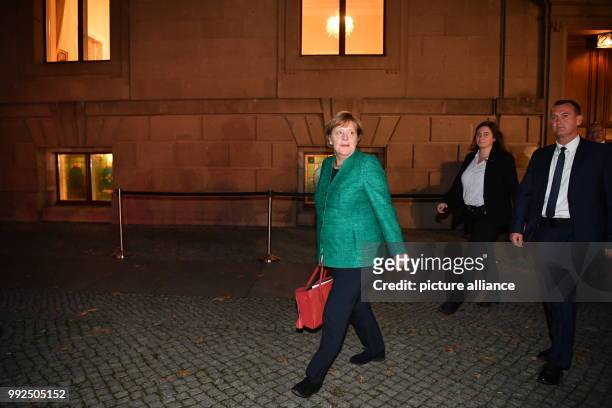 German chancellor Angela Merkel heads to her car after taking part in the first round of coalition talks to form the next government begin in Berlin,...
