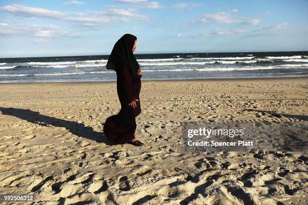 Woman walks along Rockaway Beach on July 5, 2018 in New York City. While some relief from the heat is predicted, New Yorkers have been flocking to...