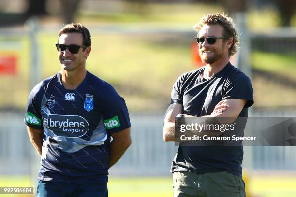 Actor Simon Baker talks to Blues assistant coach Andrew Johns during a New South Wales Blues State of Origin training session at Coogee Oval on July...