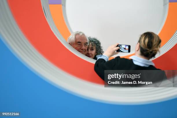 Woman photographs artist Daniel Buren and a woman with his work 'Like Child's Play ' at Carriageworks on July 6, 2018 in Sydney, Australia. It is...