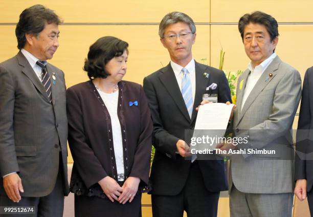 Former abductee by North Korea Hitomi Soga and mayors pose with Prime Minister Shinzo Abe during their meeting at the prime minister's official...