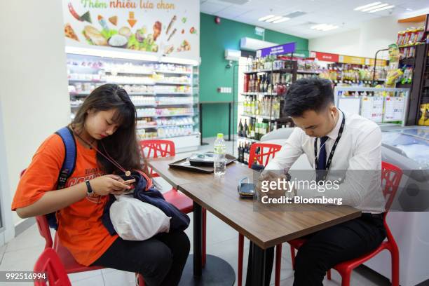 Customers sit at a table in a 7-Eleven store in Ho Chi Minh City, Vietnam, on Wednesday, June 20, 2018. For decades, Vietnamese have shopped, snacked...