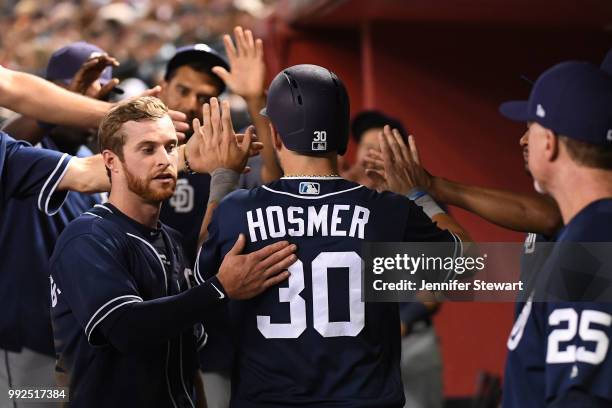 Eric Hosmer of the San Diego Padres is congratulated in the dugout after scoring in the sixth inning of the MLB game against the Arizona Diamondbacks...