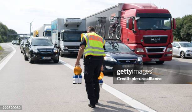 An officer of the motorway police secures the site of an accident on motorway A2 near Hanover, Germany, 25 August 2017. The 'Einsatz- und...