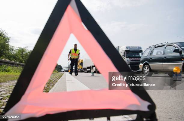 An officer of the motorway police secures the site of an accident on motorway A2 near Hanover, Germany, 25 August 2017. The 'Einsatz- und...