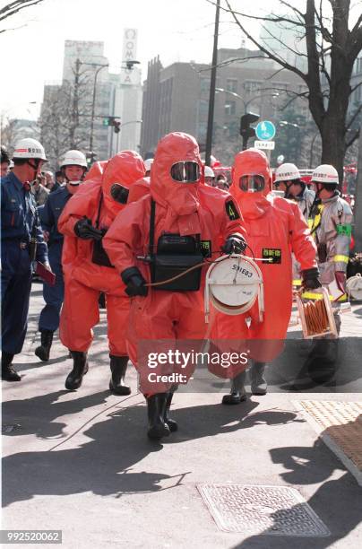 This picture taken on March 20, 1995 shows fire department officers moving into Kasumigaseki subway station following a sarin gas attack by doomsday...