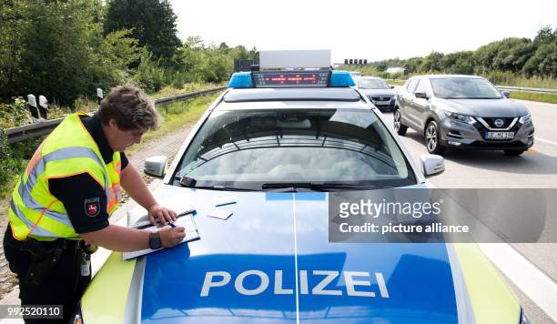 An officer of the motorway police fills in forms at the site of an accident on motorway A2 near Hanover, Germany, 25 August 2017. The 'Einsatz- und...