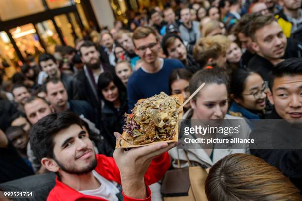 People gather to eat the world's largest doner kebab after a world record attempt in Berlin, Germany, 20 October 2017. The kebab broke the world...