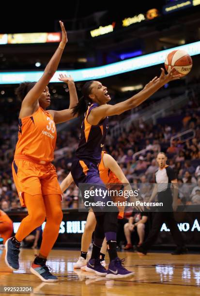 DeWanna Bonner of the Phoenix Mercury loses the ball as she drives past Morgan Tuck of the Connecticut Sun during the first half of WNBA game at...