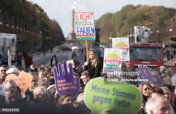 People hold placards with Anti-Racism slogans as they gather to attend a demonstration with the slogan " Against Racism and Hate in the Bundestag" to...