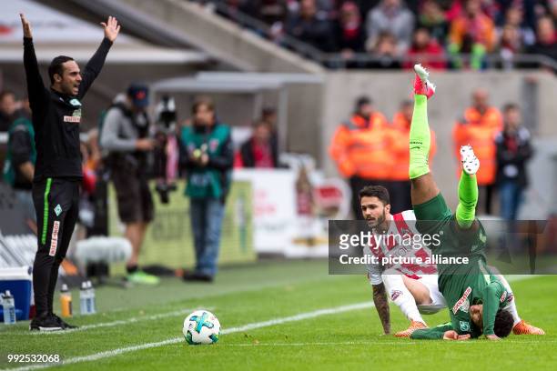 Cologne's Leonardo Bittencourt and Bremen's Theodor Gebre Selassie vie for the ball while Bremen's coach Alexander Nouri reacts at the side lines...