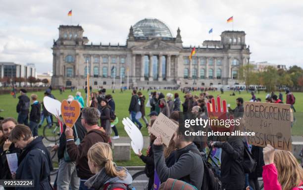 People hold placards with Anti-Racism slogans as they gather to attend a demonstration with the slogan " Against Racism and Hate in the Bundestag" to...