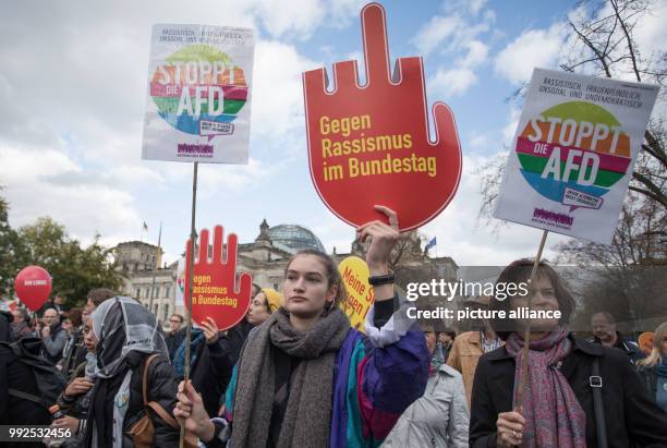 People hold placards with Anti-Racism slogans as they gather to attend a demonstration with the slogan " Against Racism and Hate in the Bundestag" to...