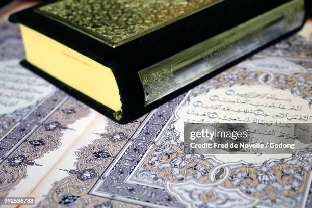 the quran on paper and tablet. - koran fotografías e imágenes de stock