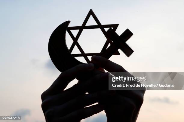 christianity, islam, judaism  3  monotheistic religions. jewish  star, cross and crescent :  interreligious symbols in hands. - estrela de david - fotografias e filmes do acervo