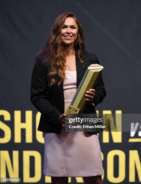 Ronda Rousey holds a trophy onstage after becoming the first female inducted into the UFC Hall of Fame at The Pearl concert theater at Palms Casino...