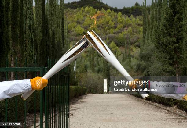 Greek biathlete and long distance ski athlete Apostolos Angelis passes the olympic fire to retired South Korean football player Park Ji-Sung in...