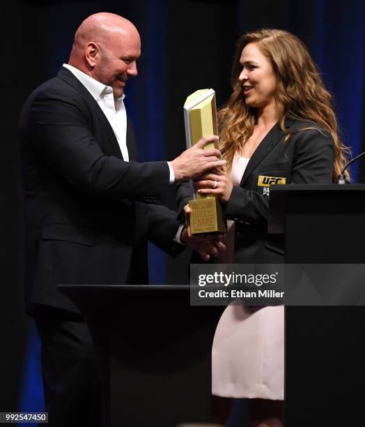 President Dana White hands a trophy to Ronda Rousey after she became the first female inducted into the UFC Hall of Fame at The Pearl concert theater...