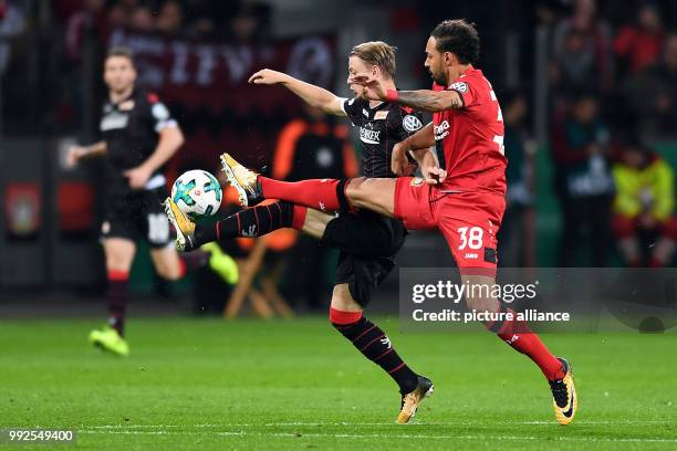 Dpatop - Leverkusen's Karim Bellarabi vies for the ball with Berlin's Simon Hedlund during the German DFB Pokal soccer cup match between Bayer...