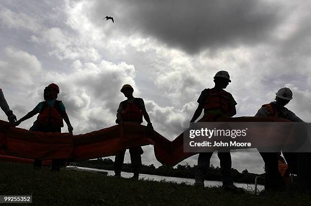 Contract workers unload oil booms to protect marshlands along the Gulf of Mexico on May 13, 2010 in Hopedale, Louisiana. The BP Deepwater Horizon oil...