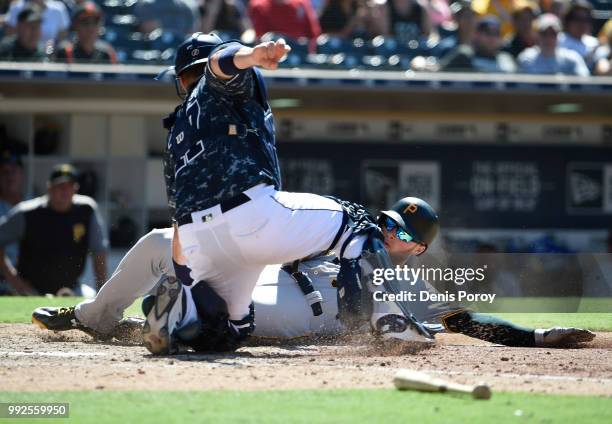 Austin Meadows of the Pittsburgh Pirates is tagged out at the plate by A.J. Ellis of the San Diego Padres during the seventh inning a baseball game...