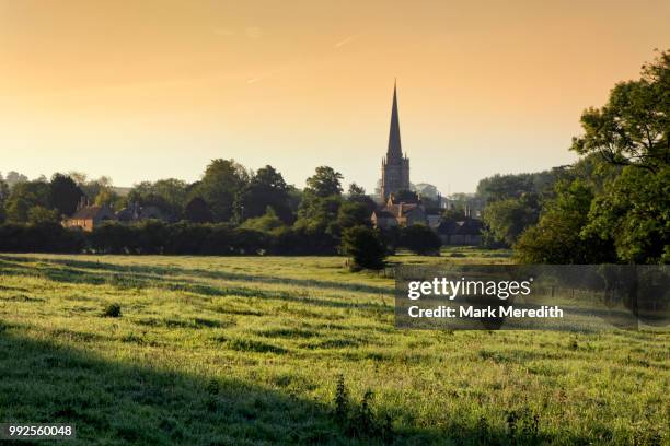 burford church spire, by the banks of the river windrush, sunset, in the cotswolds - kirchturmspitze stock-fotos und bilder