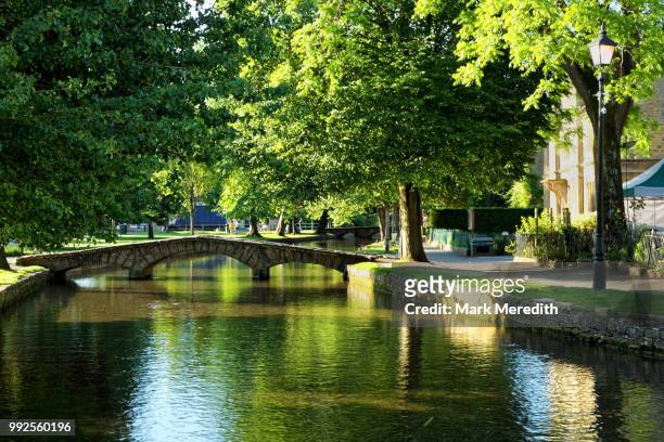 windrush river in bourton-on-the-water in the cotswolds,  gloucestershire, england - cotswolds stock pictures, royalty-free photos & images