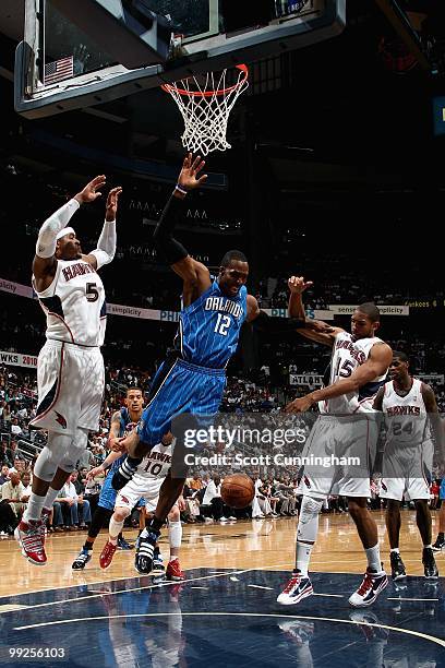 Dwight Howard of the Orlando Magic loses control of the ball under pressure from Josh Smith and Al Horford of the Atlanta Hawks in Game Three of the...