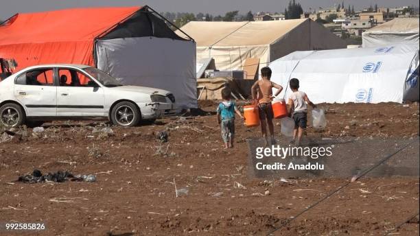 Syrian children walk on a field at the border areas near Jordan after they fled from the ongoing military operations by Bashar al-Assad regime and...