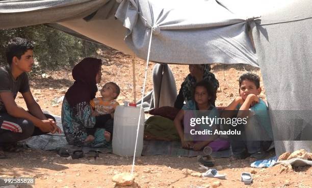 Syrian children wait at the border areas near Jordan after they fled from the ongoing military operations by Bashar al-Assad regime and its allies in...