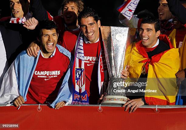 Atletico Madrid players Sergio Aguero, Raul Garcia and Jose Antonio Reyes celebrate with the trophy at the Neptuno fountain in Madrid the day after...