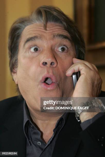 French former businessman Bernard Tapie gives a call prior to a press conference, 10 October 2006 at the Royal Monceau hotel in Paris, one day after...