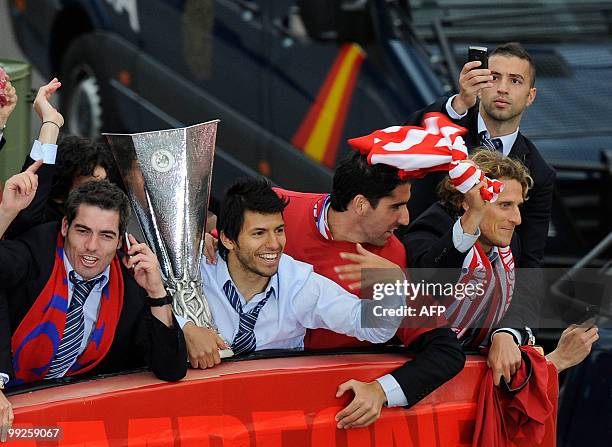 Atletico Madrid's Uruguayan forward Diego Forlan flanked by Atletico Madrid's Argentinian forward Sergio Aguero arrives at the Neptune fountain in...