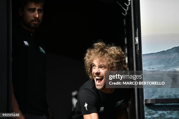 Italy's Daniel Oss jokes next to Slovakia's Peter Sagan as riders of Germany's Bora-Hansgrohe cycling team prepare to depart for a training session...